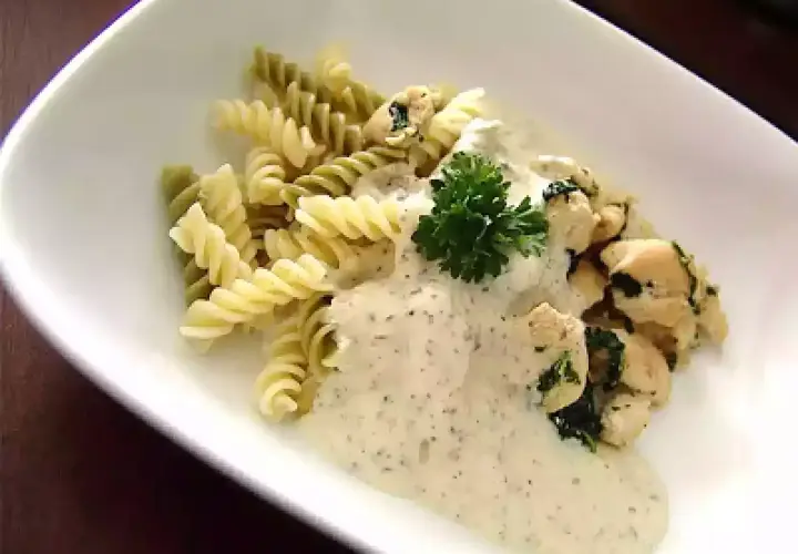 Pâtes fusilli, poulet et sauce crémeuse, garnies de persil. Un délice de pâtes pesto mozzarella.