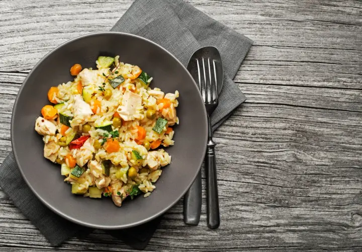 Piatto di riso con pollo e verdure miste, un esempio di alimentazione funzionale per un pasto completo e nutriente.