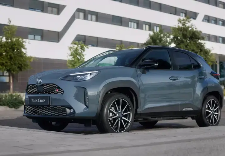 Szary Toyota Yaris Cross GR Sport na tle nowoczesnego budynku. Wiele osób szuka **toyota yaris cross opinie** przed zakupem.