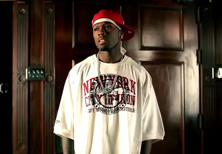 50 Cent w czerwonej czapce i białej koszulce z napisem "New York City", jak w teledysku "50 cent candy shop tekst".