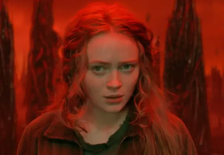 Max, le regard perdu dans le monde inversé de Stranger Things, entourée de formes sombres et menaçantes.