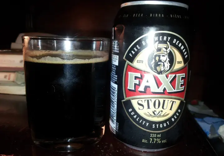Szklanka ciemnego piwa obok puszki piwa Faxe Stout. Idealne na wieczór z dobrą książką.