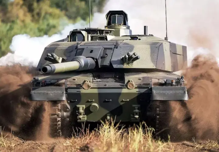 Challenger 2, potężny czołg, pędzi przez teren, wzbijając tumany kurzu i dymu.