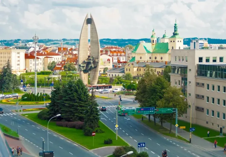 Widok na pomnik, kościół i ruchliwe skrzyżowanie w Lublinie.
