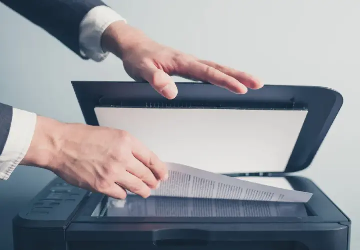 Un homme en costume utilise un scanner ged pour numériser un document important.