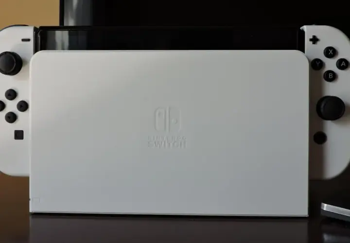 Biały Nintendo Switch z dokiem. Zastanawiasz się, czy da się podłączyć Nintendo Switch do laptopa?