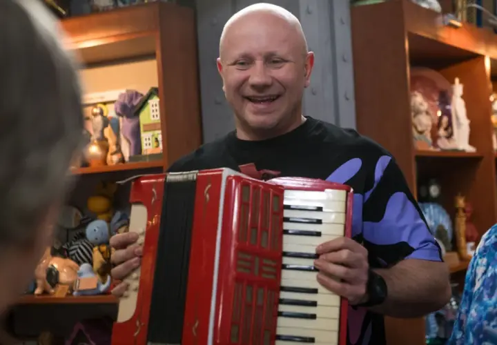 Mariusz z lombardu, grając na akordeonie, wygląda na szczęśliwego. Nie wiadomo, ile lat ma Mariusz z lombardu.