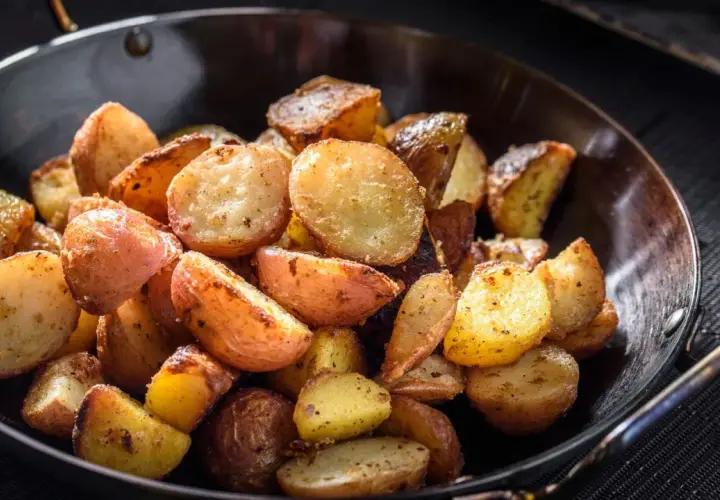 Goldbraune bratkartoffeln mit Ei, knusprig gebraten und würzig gewürzt, serviert in einer Pfanne.