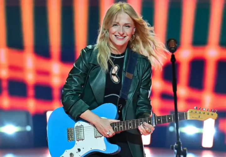 Uśmiechnięta piosenkarka z blond włosami gra na niebieskiej gitarze. Jedna z wielu utalentowanych polskich piosenkarzy na scenie.