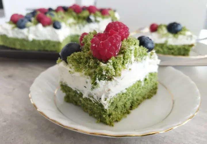 Zielony, puszysty **ciasto leśny mech na dużą blachę z serkiem mascarpone**, ozdobione malinami i borówkami.