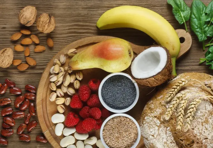 Frutta, noci, semi, legumi e pane integrale: un'abbondanza di cibi ricchi di fibre per una dieta sana.