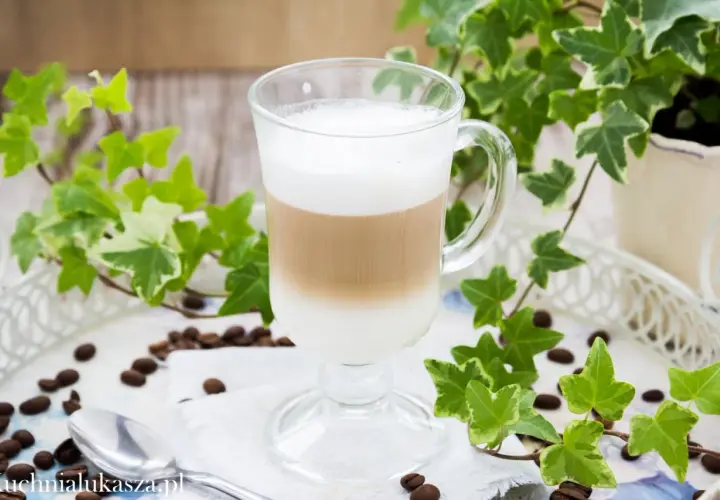 Warstwowe latte w szklance, otoczone bluszczem i ziarnami kawy. Prosty sposób, jak zrobić latte bez ekspresu.