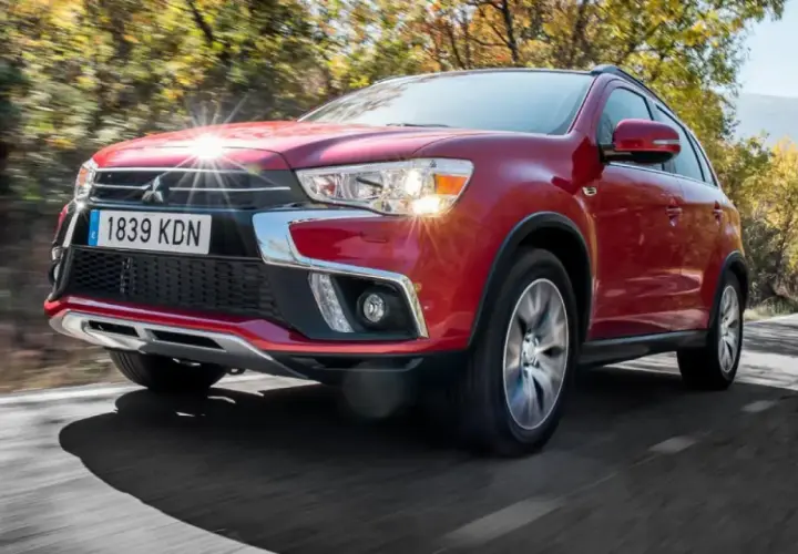 Un Mitsubishi ASX rojo circula por una carretera rural. A pesar de su diseño, algunos propietarios han reportado problemas del Mitsubishi ASX.