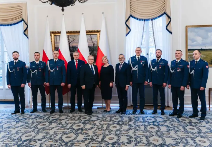 Grupa osób w mundurach i garniturach, być może związana z sekrety ochrony prezydenta i incydenty z drona pod rezydencją w marcu 2026.