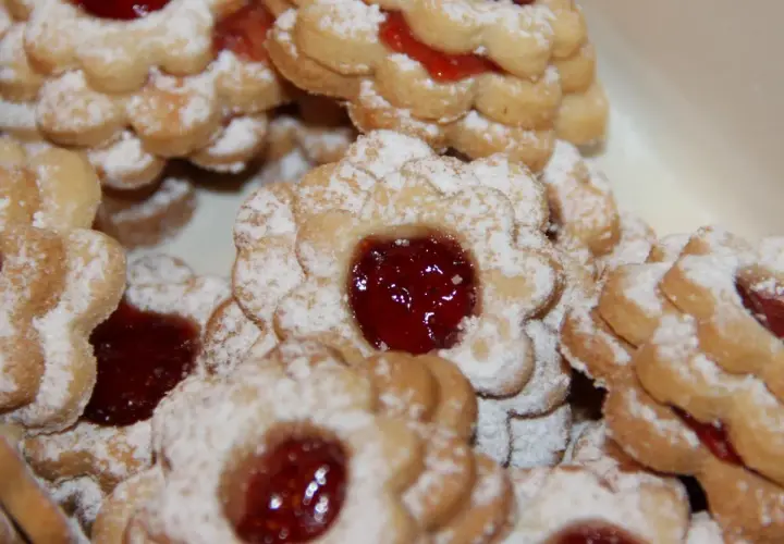 Stos ciastek maślanych z dżemem, oprószonych cukrem pudrem. Idealne na popołudniową herbatę.