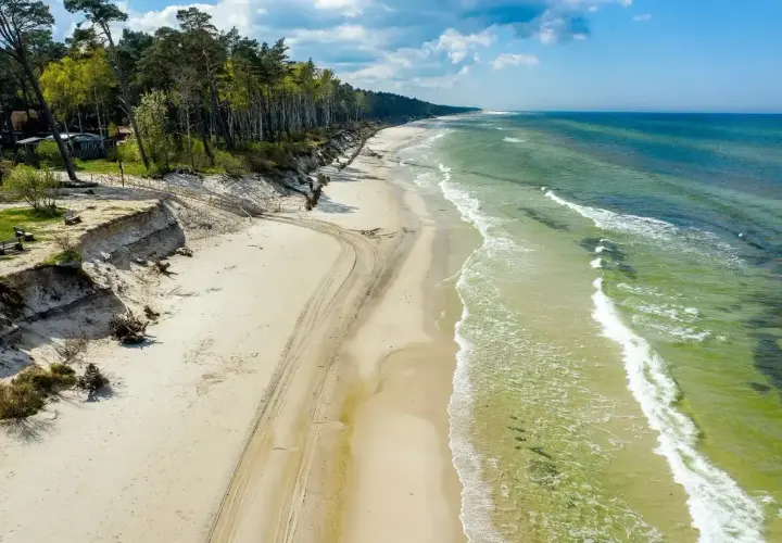 Piękna plaża z sosnowym lasem, idealna na weekendowy wypad. Zastanawiasz się, gdzie najbliżej nad morze z Poznania? To miejsce może być odpowiedzią!