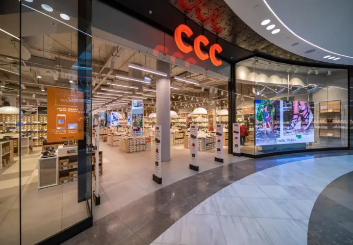 Wejście do sklepu CCC z widocznym logo, półkami z butami i ekranem LED.