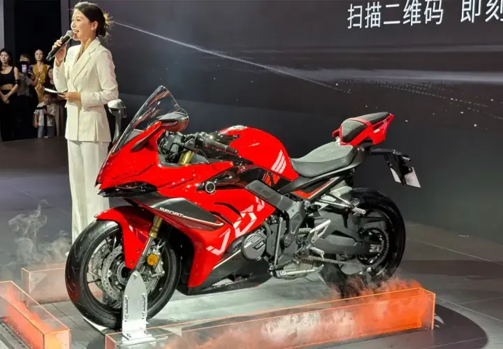 Presentación de la Voge 666 RR, una moto deportiva roja brillante, con una presentadora hablando al micrófono.