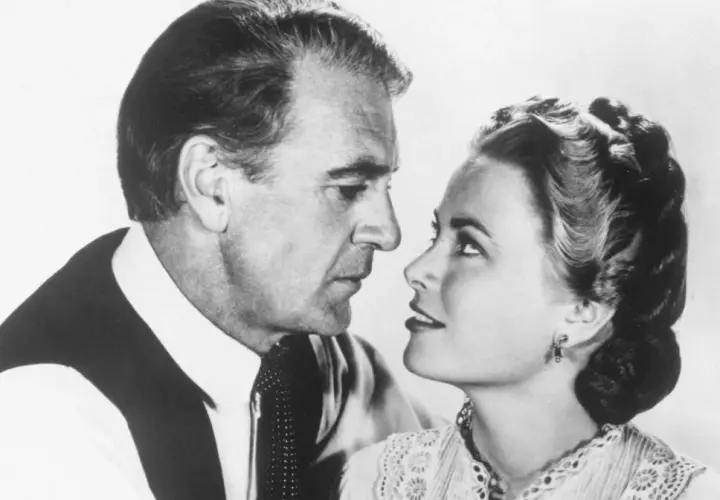 W samo południe obsada: Gary Cooper i Grace Kelly w zbliżeniu, patrzą na siebie z intensywnością.