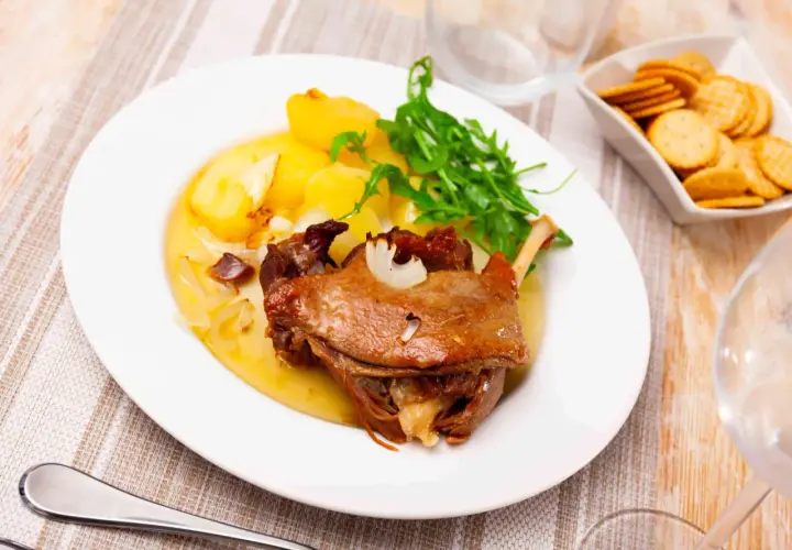 Confit de canard avec pommes de terre rôties et roquette. Une idée de quels légumes servir avec du confit de canard pour un repas parfait.