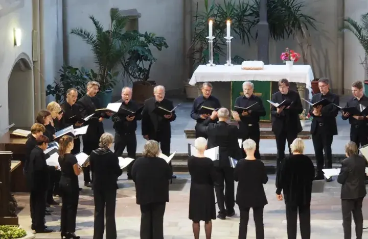 Chor singt in Kirche. Ein Dirigent leitet. Hier finden Sie kirchenmusik stellenangebote.