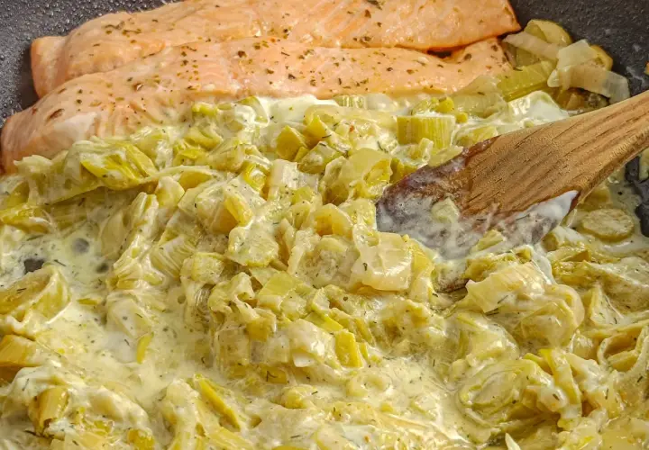 Saumon poêlé avec une sauce crémeuse aux poireaux. Une recette simple et savoureuse pour un dîner rapide.