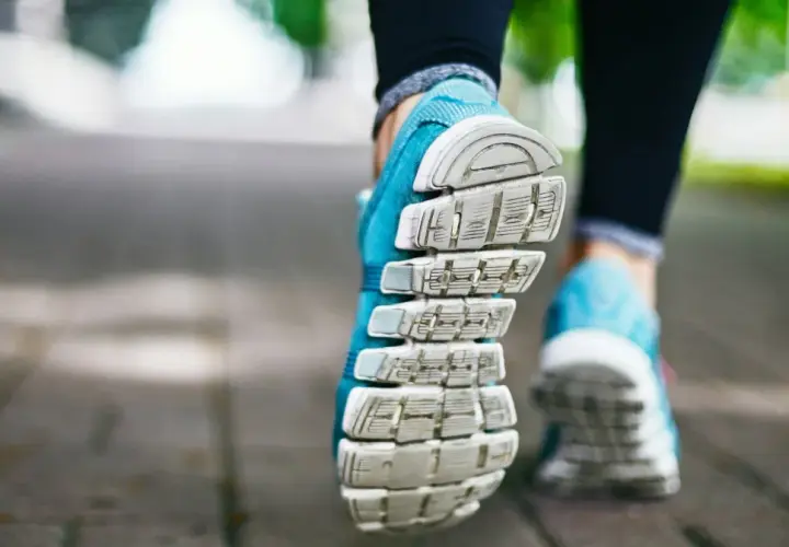 Niebieskie buty sportowe na chodniku, gotowe na szybki marsz czy bieganie.