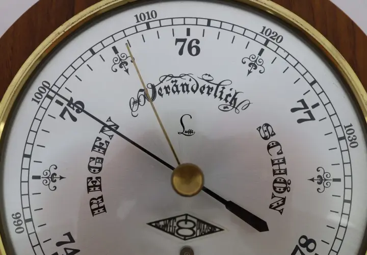Barometr z tarczą wskazującą ciśnienie atmosferyczne. Wskazówka pokazuje "Veränderlich" (zmiennie), co oznacza, że ciśnienie co to jest kluczowe dla pogody.
