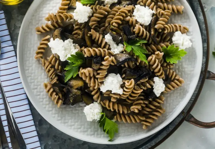 Fusilli integrali con melanzane grigliate, ricotta fresca e prezzemolo. Un piatto estivo leggero e gustoso.