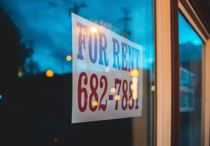 Szyba z napisem "FOR RENT" i numerem telefonu. Czy to dzierżawa, czy najem? Zadzwoń i się dowiedz!