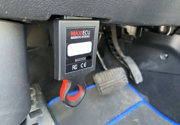Interfejs diagnostyczny MaxiECU podłączony do portu OBD w Dacia Duster.