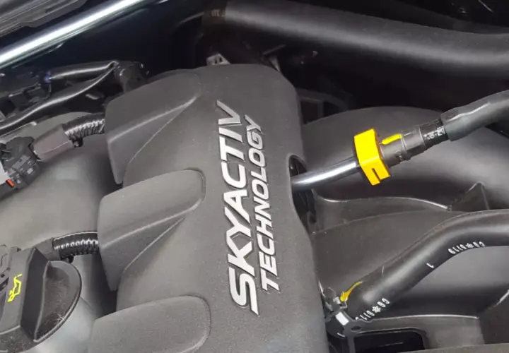 Silnik SKYACTIV TECHNOLOGY, jeden z najlepszych silników benzynowych, z widocznymi przewodami i złączkami.
