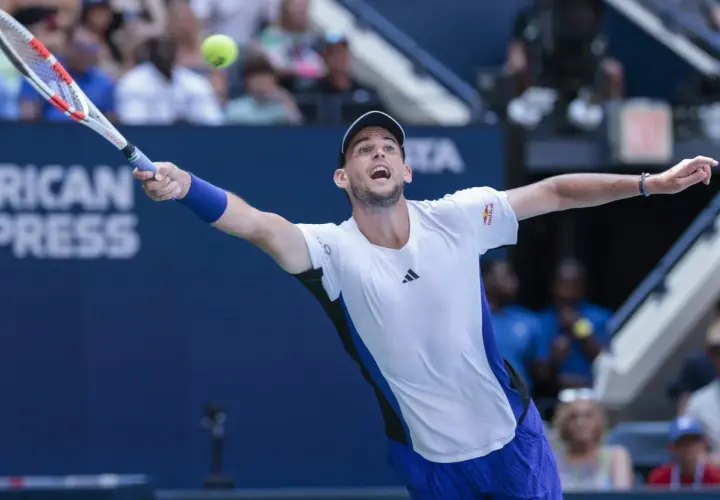 Dominic Thiem w akcji, uderza piłkę rakietą na korcie tenisowym.
