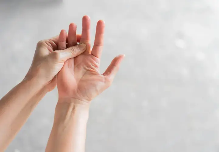 Mani che si massaggiano le dita, un gesto per alleviare il formicolio nel corpo causato dallo stress.