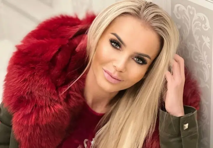 Monika Chwajoł w stylowej, czerwonej kurtce z futrem. Jej mąż z pewnością docenia jej modowy gust.