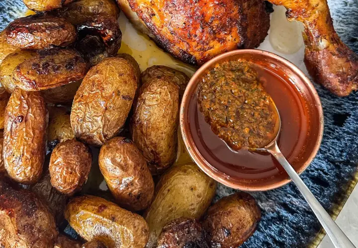 Un plat de poulet portugais rôti avec des pommes de terre dorées et une sauce savoureuse.