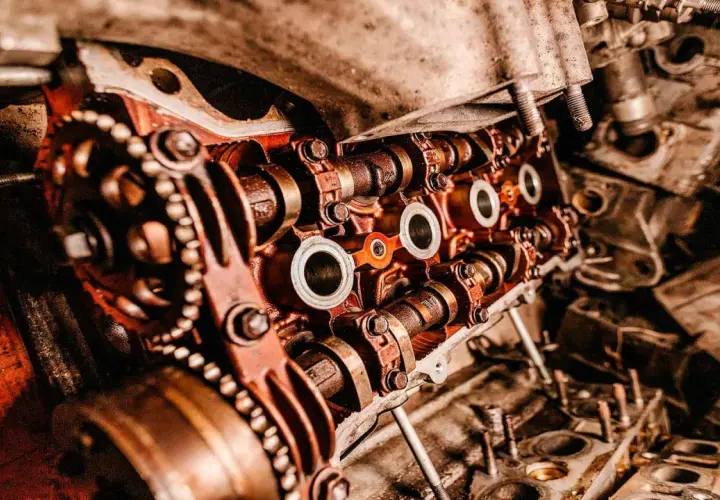 Primer plano de un motor de coche con engranajes y levas, mostrando las piezas de desgaste de un coche.