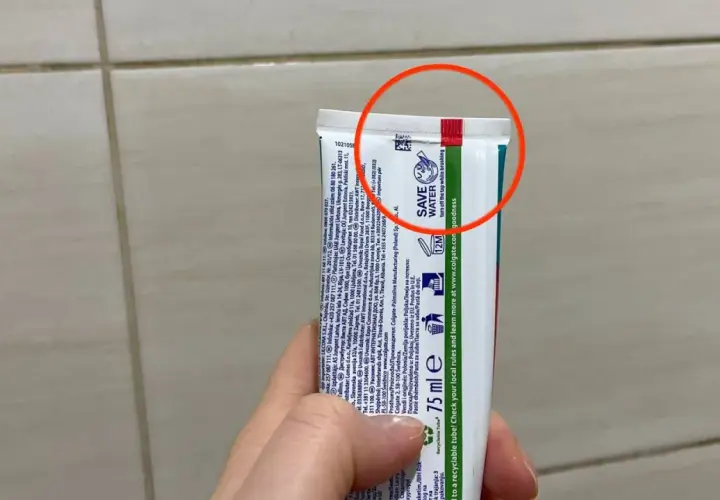 Czerwony pasek na tubce pasty do zębów informuje, że opakowanie jest wykonane z materiału, który można poddać recyklingowi.