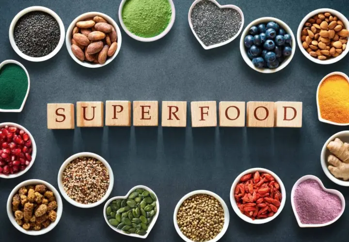 Scopri quali sono i superfood: semi di chia, mirtilli, mandorle, curcuma, zenzero, bacche di goji e altro ancora, disposti attorno alla parola "SUPERFOOD".