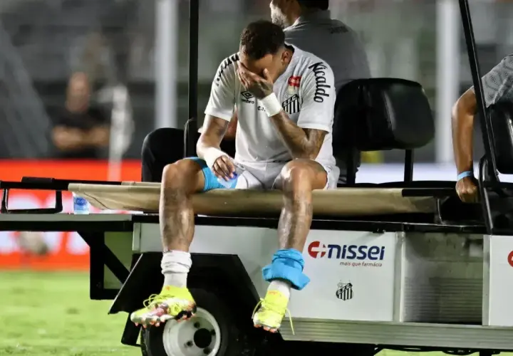 Neymar siedzi na wózku, zakrywając twarz dłońmi. Wygląda na to, że jego **neymar kontuzja** jest poważna.