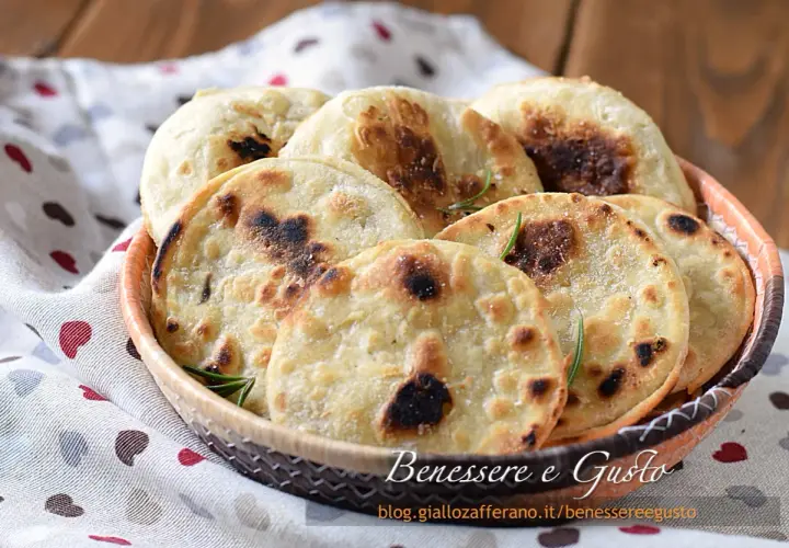 Focaccia senza lievito dorata e fragrante, servita in un cestino, con rosmarino e sale grosso. Perfetta per un pasto veloce e gustoso.