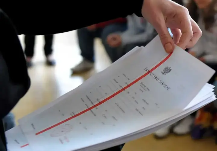 Dłoń trzyma świadectwo szkolne. Zastanawiasz się, czy religia wlicza się do średniej?