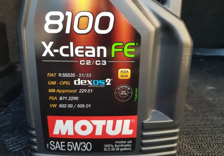 Czarna butelka oleju silnikowego Motul 8100 X-clean FE 5W30 z widocznymi specyfikacjami.