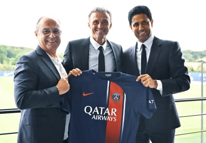 Luis Enrique, nowy trener PSG, prezentuje koszulkę klubu z prezesem i dyrektorem sportowym.