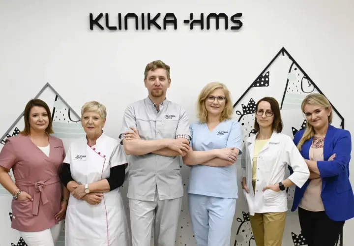 Zespół medyczny Kliniki HMS w Zielonej Górze: sześć osób w strojach medycznych i garniturze.