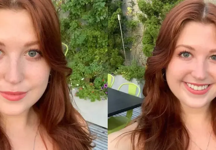 Mujer con cabello largo y ondulado en tonos tinte pelirrojo, ojos azules y pecas, sonríe en un entorno exterior con vegetación.