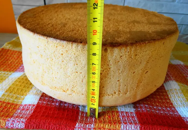 Idealny biszkopt na tort, zmierzony miarką, ma około 7 cm wysokości. Puszysty i złocisty, gotowy do dekoracji.
