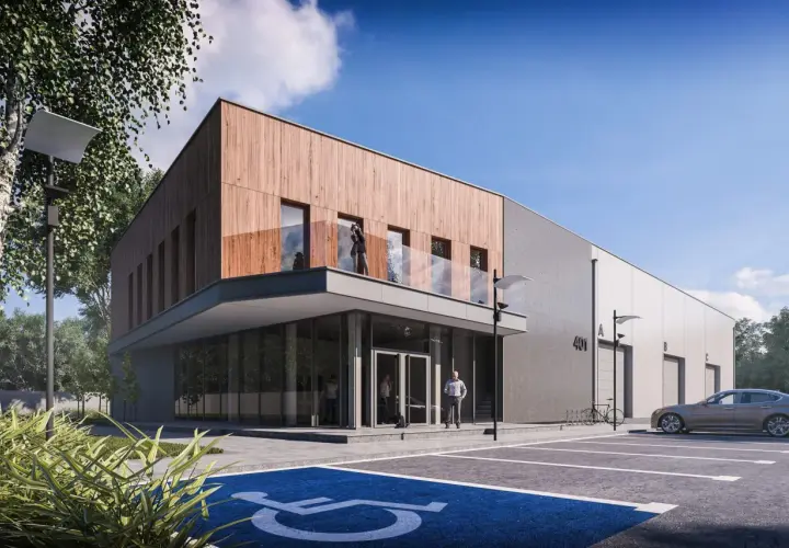 Nowoczesne projekty magazynów z drewnianą elewacją i betonem. Przed budynkiem parking z miejscem dla niepełnosprawnych i samochodem.