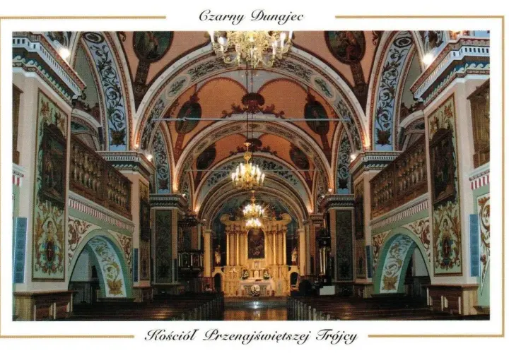 Wnętrze kościoła Przenajświętszej Trójcy w Czarnym Dunajcu. Bogato zdobione sklepienia, ołtarz i ławy tworzą uroczystą atmosferę.