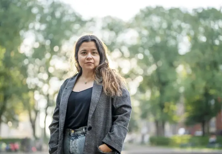 Caroline Ringskog Ferrada-Noli, partner, står utomhus i en park med träd i bakgrunden.
